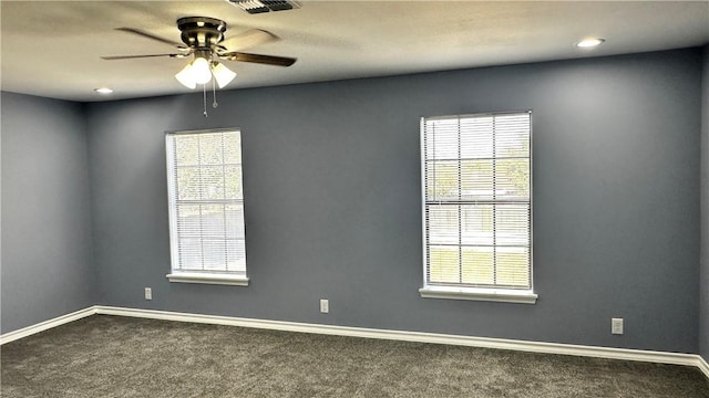 unfurnished room featuring ceiling fan, dark colored carpet, and baseboards