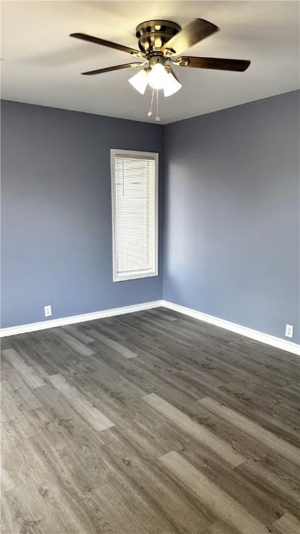 spare room featuring ceiling fan, baseboards, and wood finished floors