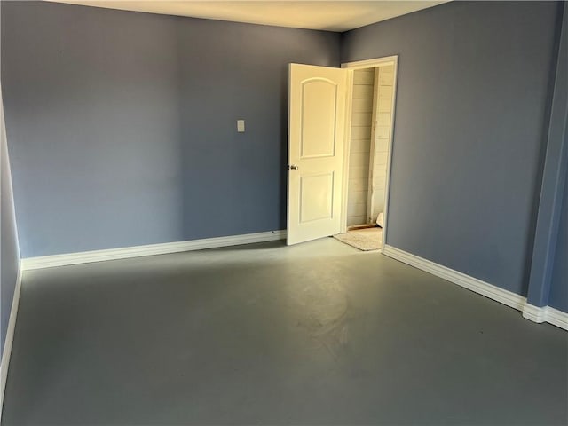 spare room with concrete floors and baseboards