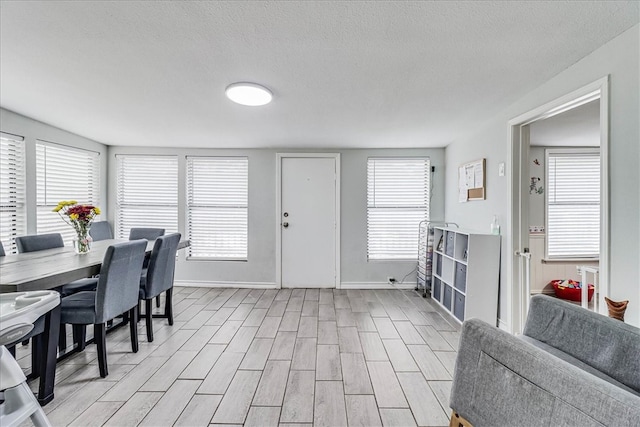 dining space with light hardwood / wood-style flooring and a textured ceiling