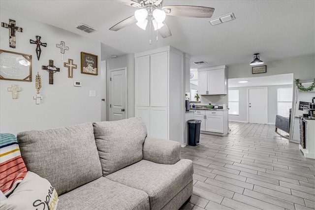 living room featuring light wood-type flooring and ceiling fan