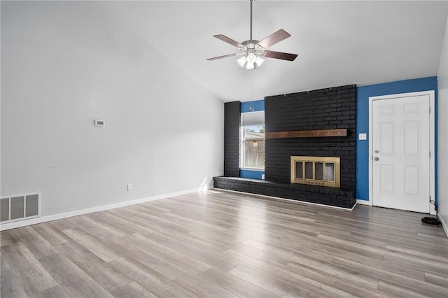 unfurnished living room with hardwood / wood-style flooring, ceiling fan, lofted ceiling, and a fireplace