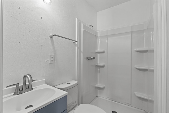 bathroom with toilet, a shower, and vanity