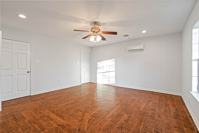 empty room with a wall unit AC, ceiling fan, wood-type flooring, and wood walls