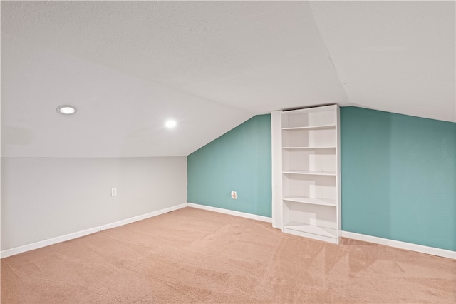 bonus room with carpet, built in shelves, and lofted ceiling