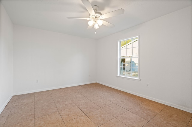 tiled spare room featuring ceiling fan