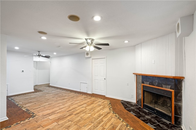 living room with ceiling fan, light wood-type flooring, and a fireplace