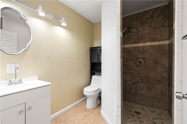 bathroom featuring tile patterned floors, vanity, toilet, and a tile shower