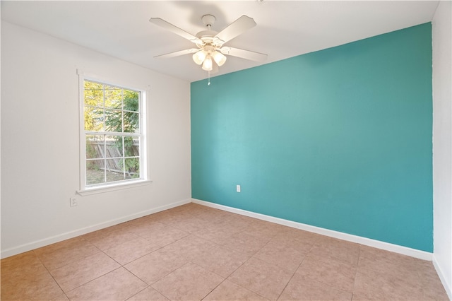 tiled spare room featuring ceiling fan