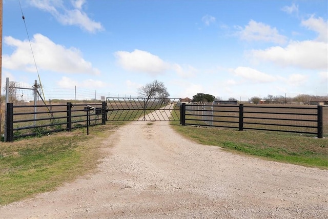 view of gate with a rural view and fence