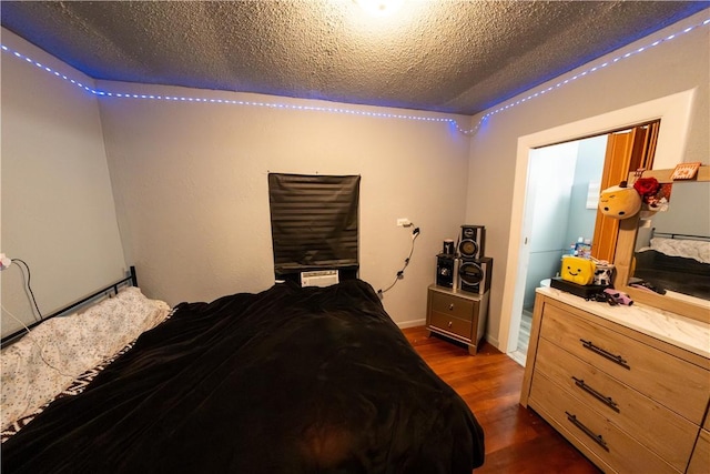 bedroom with a textured ceiling and dark wood-style flooring