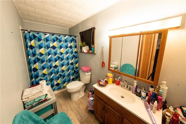 bathroom featuring curtained shower, vanity, toilet, and wood finished floors