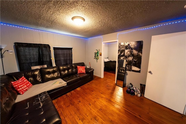 living area with a textured ceiling and wood-type flooring