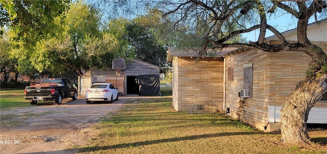 view of property exterior with an outbuilding, a yard, and driveway