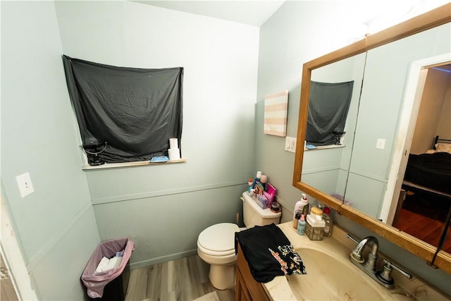 bathroom featuring vanity, wood finished floors, and toilet