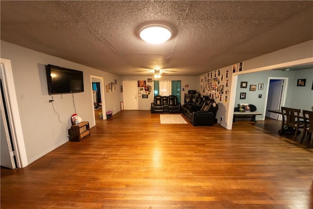 unfurnished living room with a textured ceiling and wood finished floors