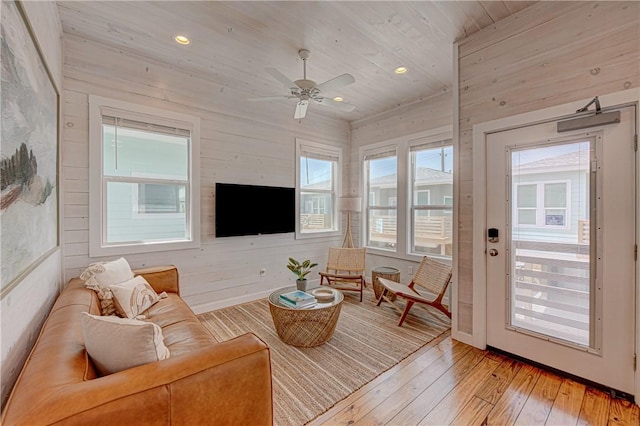 living room featuring wood ceiling, wooden walls, light hardwood / wood-style floors, and ceiling fan