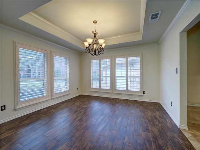 empty room featuring a tray ceiling, visible vents, and plenty of natural light