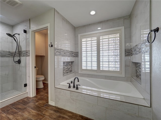 full bath with wood finish floors, visible vents, toilet, a shower stall, and a bath