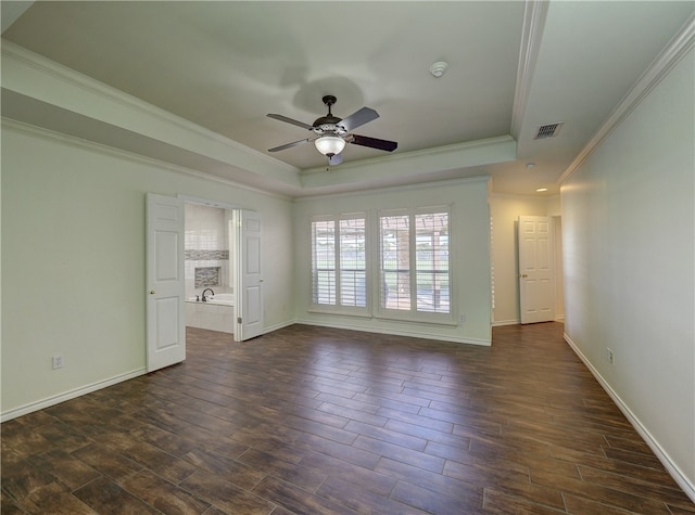 unfurnished room featuring ceiling fan, visible vents, dark wood finished floors, baseboards, and a raised ceiling