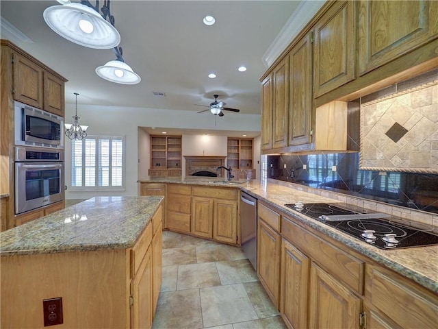 kitchen with light stone counters, a peninsula, a fireplace, a sink, and appliances with stainless steel finishes