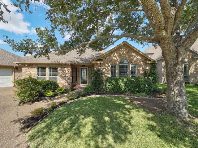 ranch-style house with a garage and a front lawn