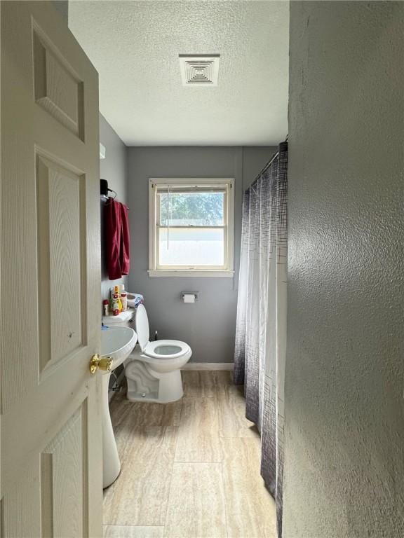 769 W Cornelia, Corpus Christi, TX 78408 - bathroom with wood finished floors, a textured ceiling, and a shower with curtain