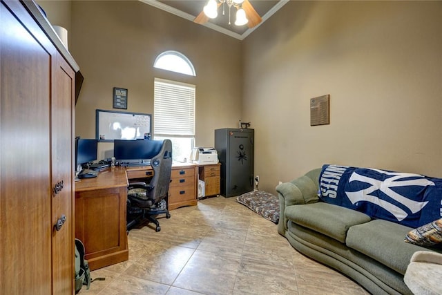 tiled office with ceiling fan, crown molding, and a towering ceiling