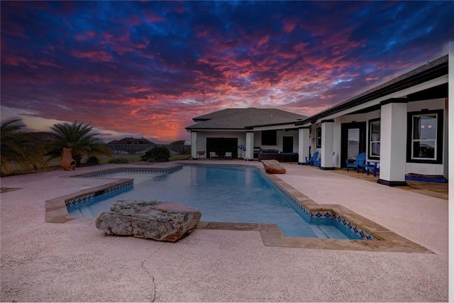 pool at dusk with a patio