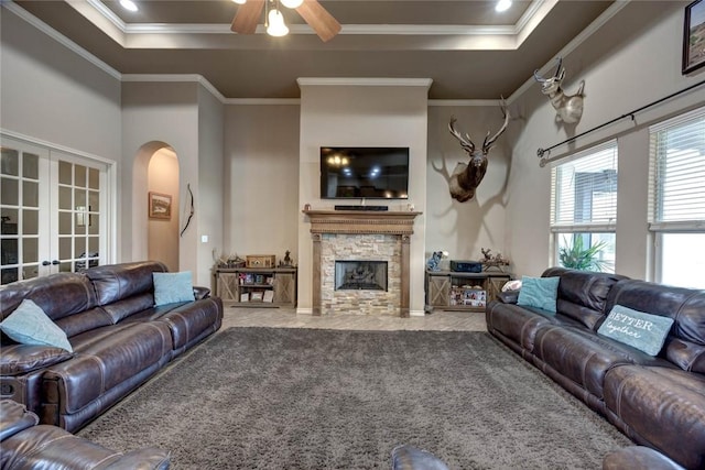 living room with ceiling fan, ornamental molding, french doors, and a fireplace