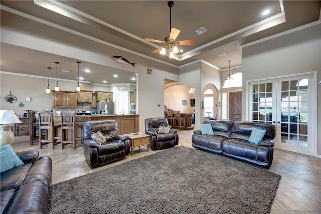 living room with french doors, ceiling fan, crown molding, and a raised ceiling