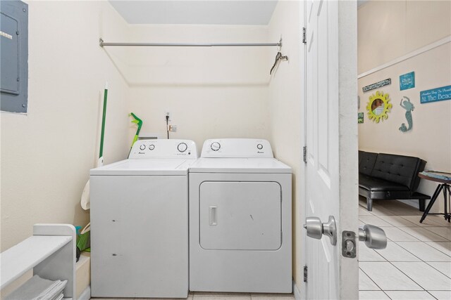 washroom featuring washing machine and dryer, electric panel, and light tile patterned floors