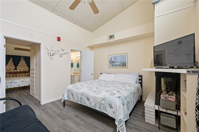 bedroom with hardwood / wood-style floors, ensuite bathroom, high vaulted ceiling, and ceiling fan