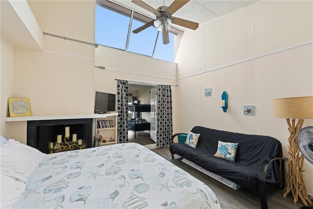 bedroom featuring ceiling fan, dark wood-type flooring, and wood walls