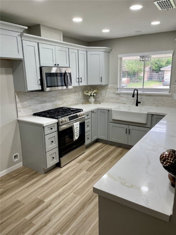 4917 Arlene Dr, Corpus Christi, TX 78411 - kitchen with appliances with stainless steel finishes, a sink, light wood-type flooring, backsplash, and recessed lighting