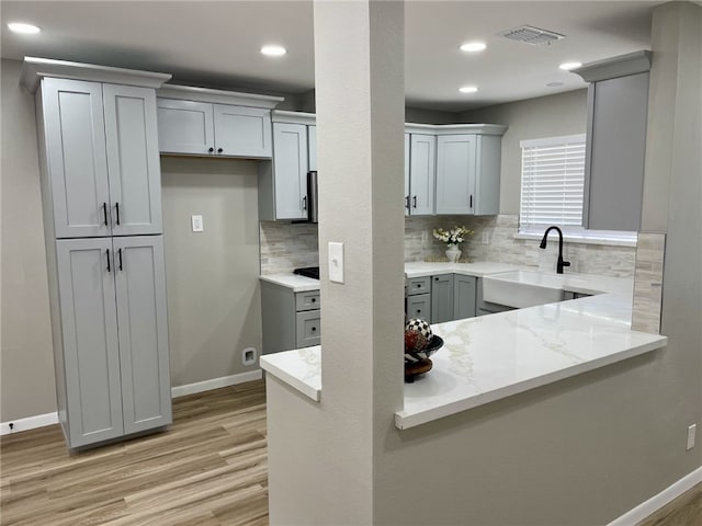 4917 Arlene Dr, Corpus Christi, TX 78411 - kitchen featuring a sink, light wood-style flooring, backsplash, gray cabinets, and recessed lighting