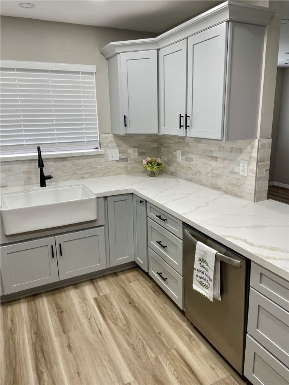 4917 Arlene Dr, Corpus Christi, TX 78411 - kitchen with a sink, stainless steel dishwasher, gray cabinetry, backsplash, and light wood finished floors