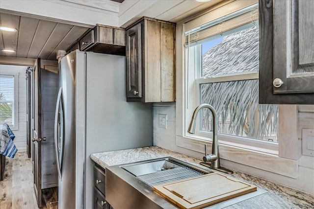 kitchen featuring dark brown cabinets, a healthy amount of sunlight, and light hardwood / wood-style flooring