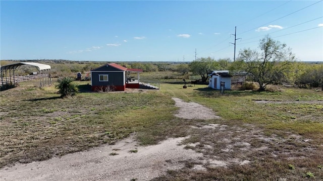 view of yard with a rural view and a shed