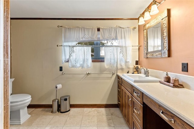 bathroom with vanity, toilet, and crown molding