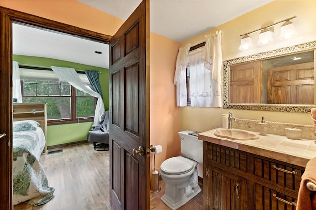 bathroom featuring wood-type flooring, vanity, and toilet