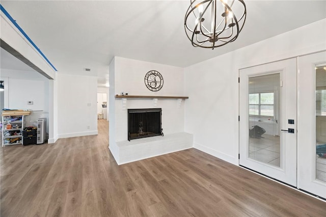 1406 Hwy 72, Three Rivers, TX 78071 - unfurnished living room featuring a chandelier, wood finished floors, and a fireplace