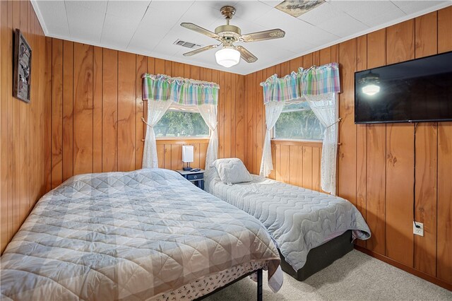 bedroom featuring carpet floors, ceiling fan, and wooden walls