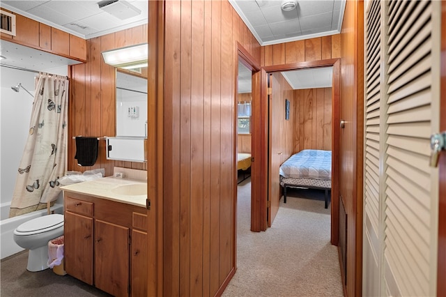 full bathroom featuring wood walls, shower / tub combo with curtain, vanity, and toilet