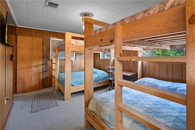 carpeted bedroom with wooden walls