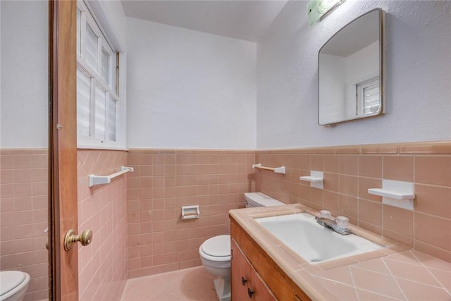 3730 Fort Worth St, Corpus Christi, TX 78411 - half bath featuring toilet, tile walls, a wainscoted wall, vanity, and tile patterned flooring