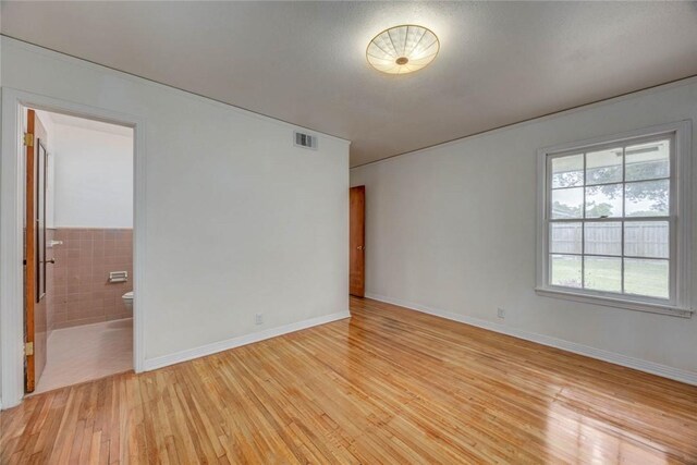 3730 Fort Worth St, Corpus Christi, TX 78411 - spare room with light wood finished floors, tile walls, and a wainscoted wall