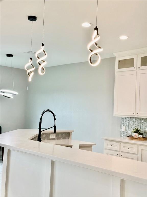 4122 Nadia Dr, Corpus Christi, TX 78414 - kitchen featuring a sink, decorative backsplash, light countertops, and white cabinets