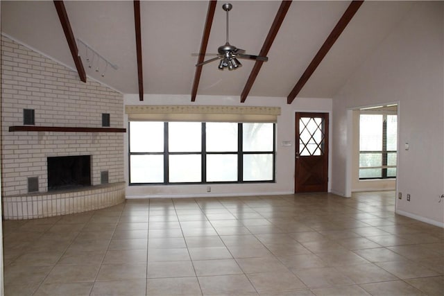 unfurnished living room with a brick fireplace, plenty of natural light, ceiling fan, and beam ceiling