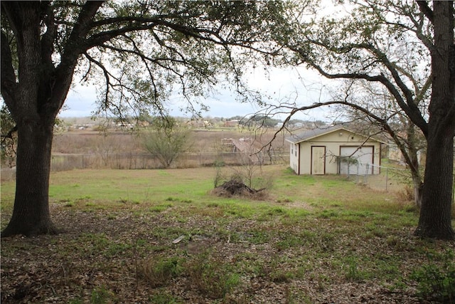 view of yard with a rural view and a storage shed